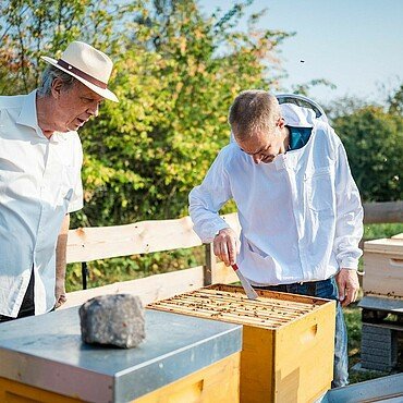 Jens Bössen und Imker Matthias Roth überprüfen den Zustand im Bienenstock im Waldbadviertel