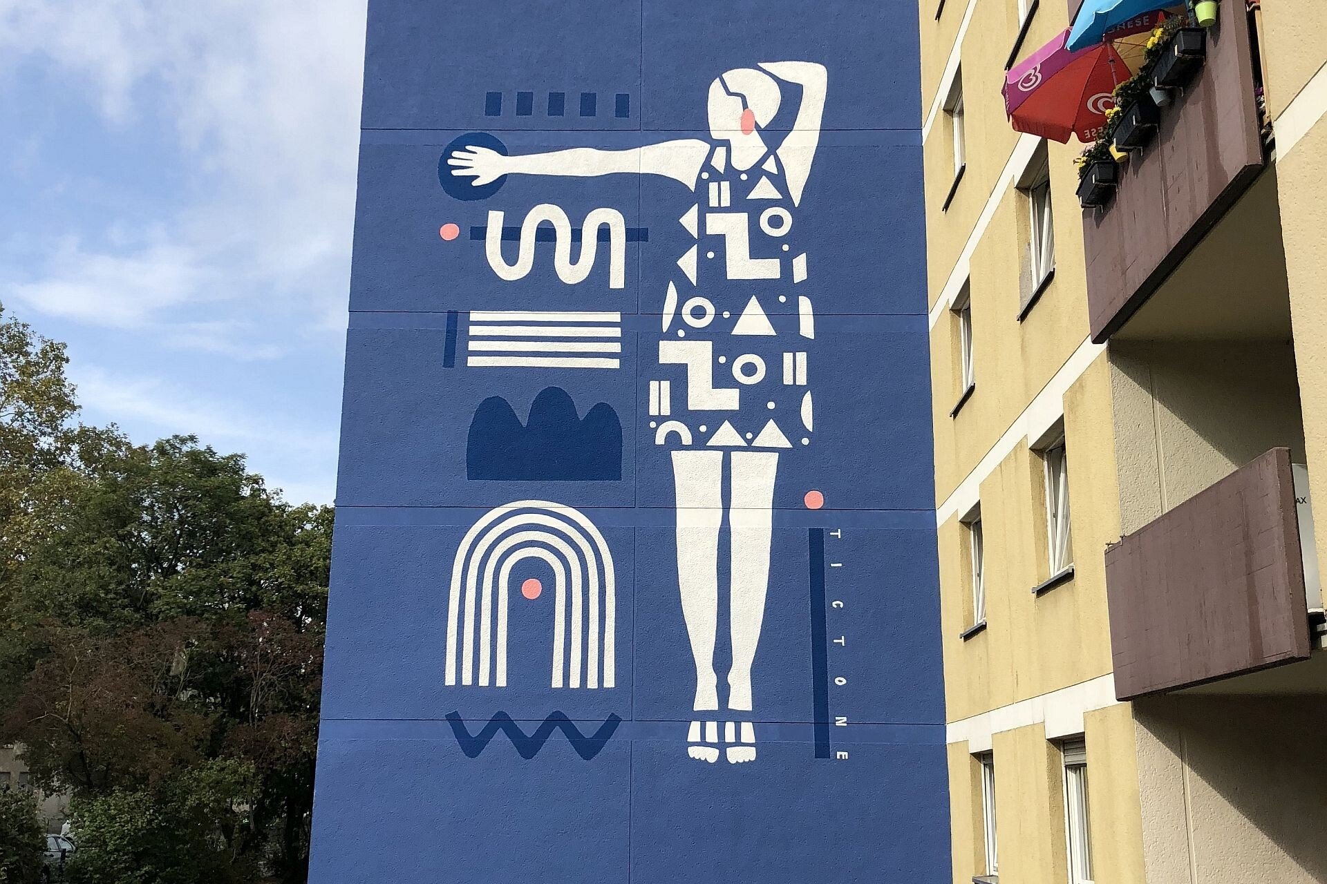 Mural in Müngersdorf zeigt eine Frau mit Kleid aus geometrischen Formen